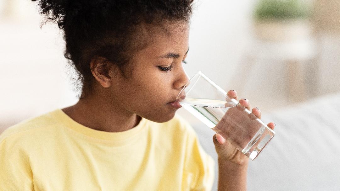 Young Child Drinking Water From Glass